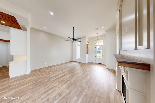 unfurnished living room featuring light wood-style floors, visible vents, ornamental molding, and baseboards