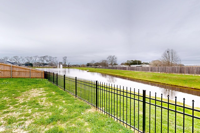 view of yard with a water view and a fenced backyard