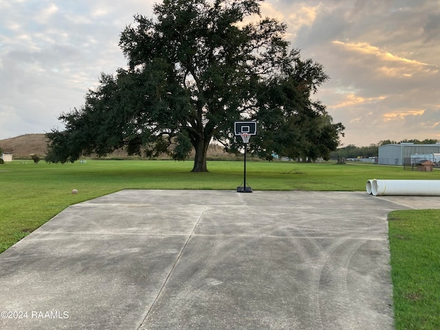 view of basketball court with a yard