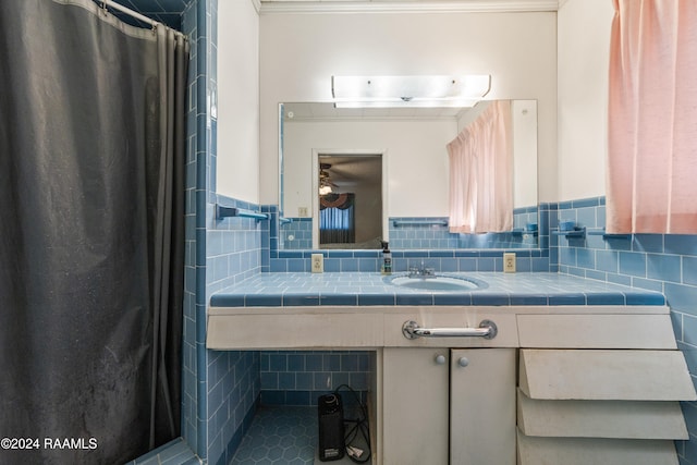 bathroom with walk in shower, vanity, and tile walls