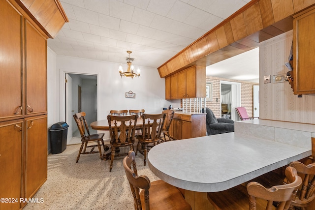 dining space with crown molding and a notable chandelier