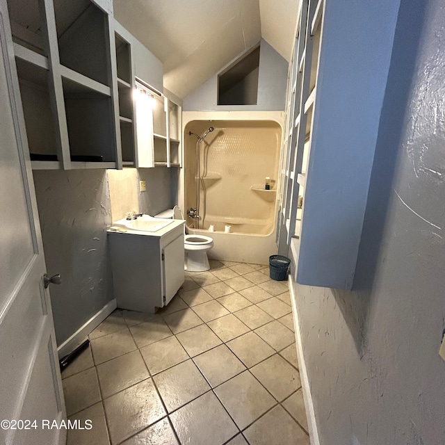 full bathroom with washtub / shower combination, toilet, lofted ceiling, vanity, and tile patterned flooring