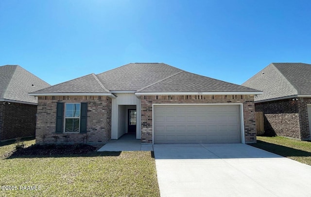 view of front of property featuring brick siding, a front lawn, concrete driveway, roof with shingles, and a garage