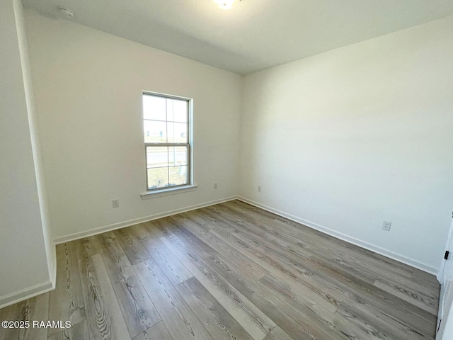 unfurnished room featuring baseboards and wood finished floors