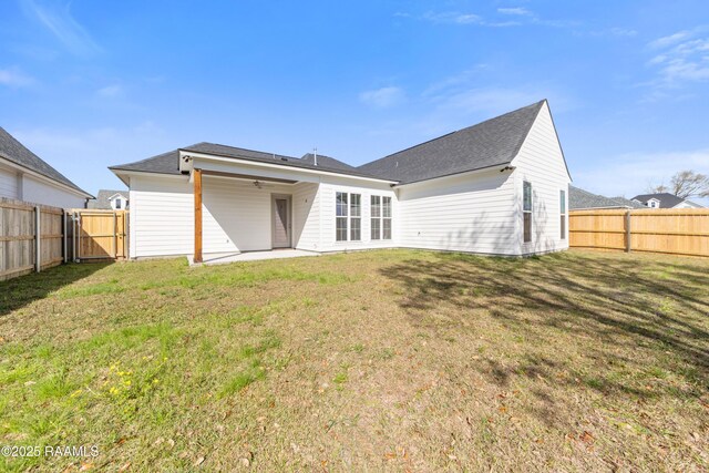 rear view of property featuring a ceiling fan, a patio area, a yard, and a fenced backyard