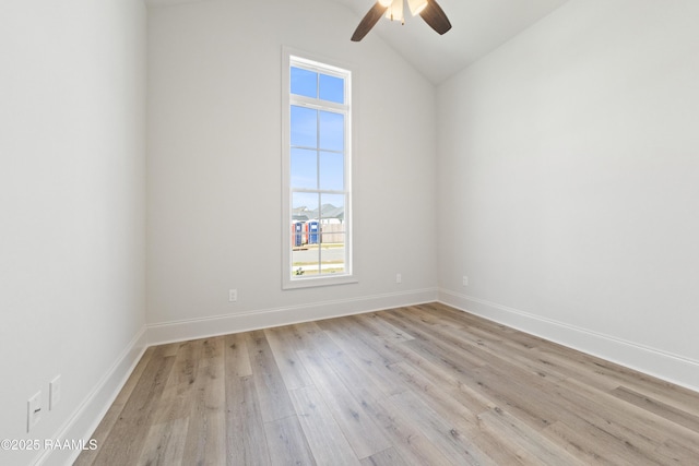 unfurnished room with baseboards, a ceiling fan, light wood-style floors, and vaulted ceiling