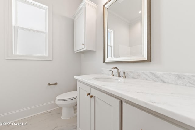 bathroom featuring toilet, marble finish floor, ornamental molding, baseboards, and vanity