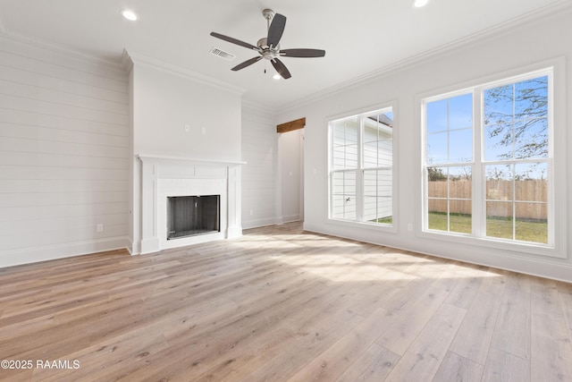 unfurnished living room with visible vents, crown molding, a fireplace, light wood-style floors, and a ceiling fan