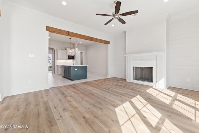 unfurnished living room with light wood finished floors, visible vents, crown molding, recessed lighting, and a fireplace