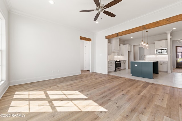 unfurnished living room featuring ornamental molding, ceiling fan with notable chandelier, recessed lighting, light wood-style floors, and baseboards