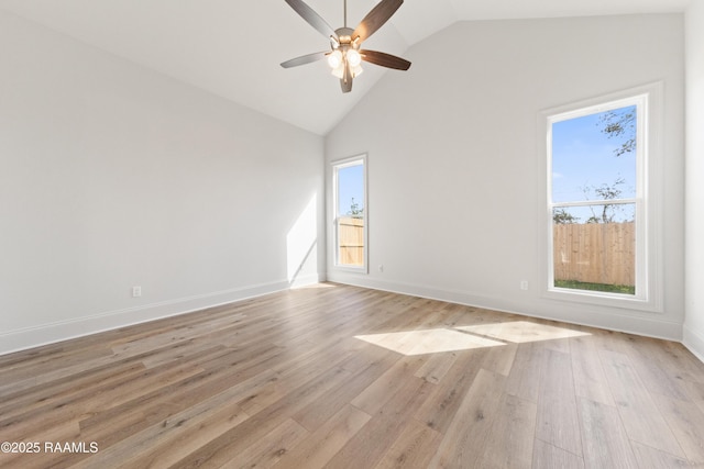 spare room with baseboards, high vaulted ceiling, a ceiling fan, and light wood finished floors