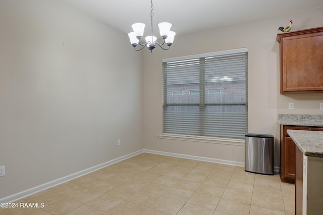 unfurnished dining area featuring an inviting chandelier and light tile patterned flooring