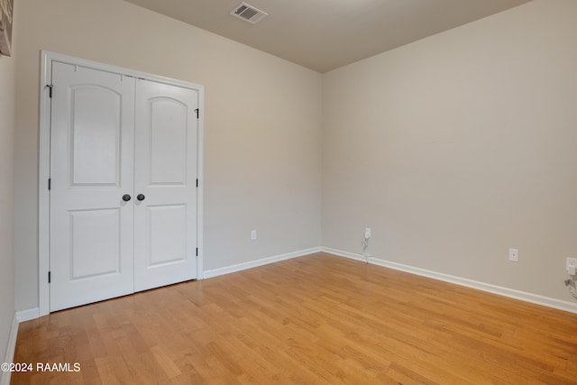 unfurnished bedroom featuring a closet and light hardwood / wood-style floors