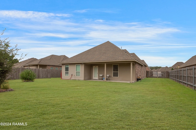 rear view of house with a yard and a patio area