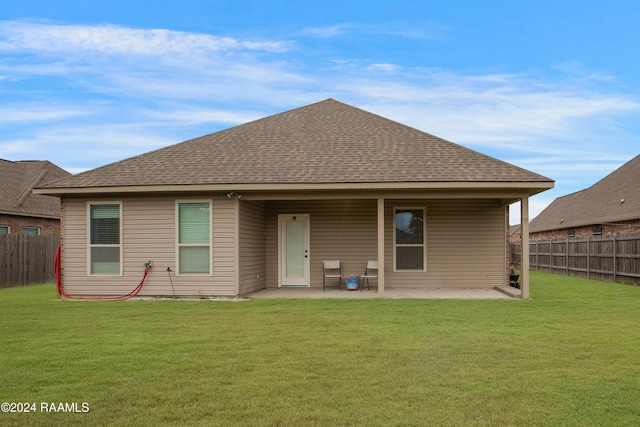 back of property with a patio area and a lawn