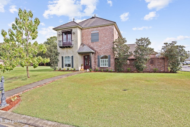 view of front of house featuring a front lawn and a balcony