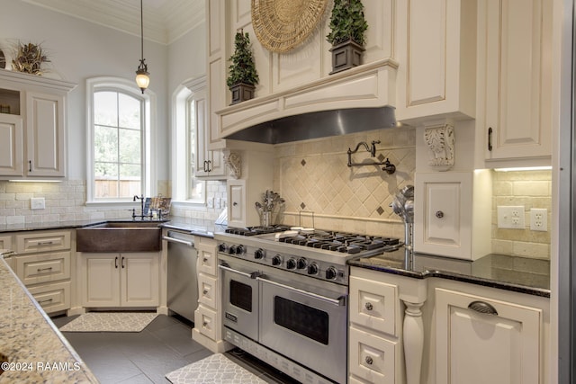 kitchen featuring stainless steel appliances, hanging light fixtures, tasteful backsplash, dark tile patterned floors, and dark stone countertops