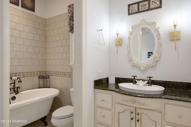 bathroom featuring a bathing tub, tile walls, vanity, and toilet