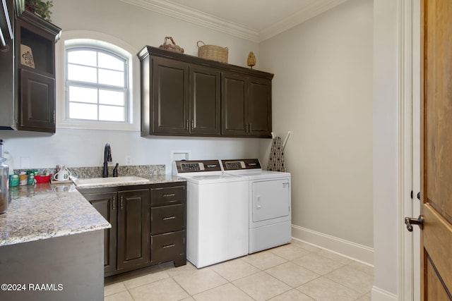 washroom with cabinets, sink, ornamental molding, light tile patterned floors, and washer and clothes dryer