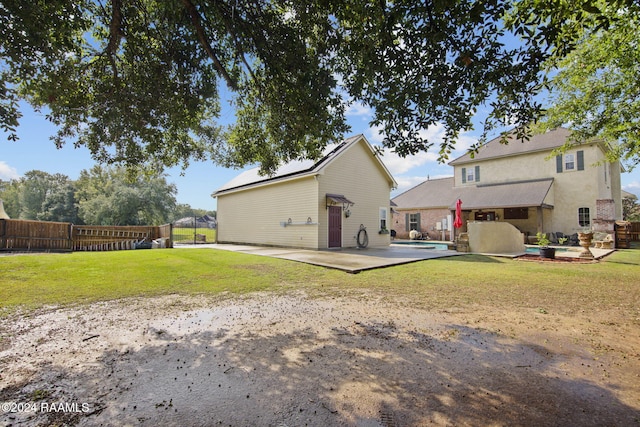 back of house featuring a fenced in pool, a patio, and a lawn