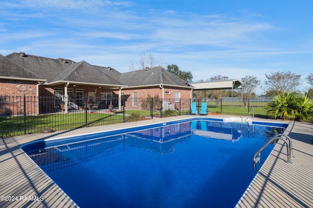 view of swimming pool featuring a yard