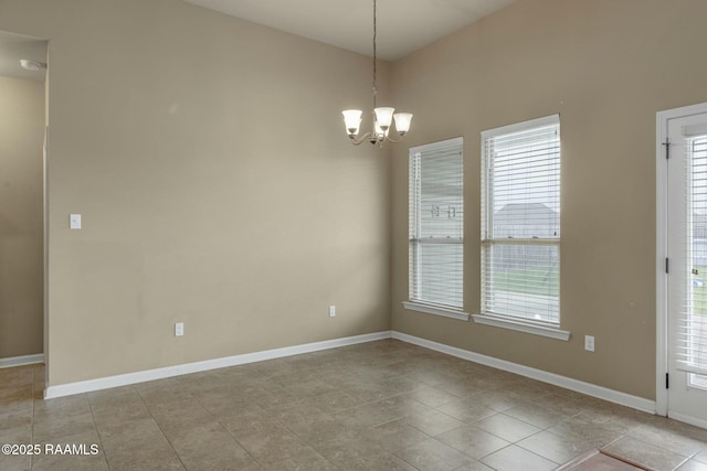 unfurnished room with a chandelier and light tile patterned floors