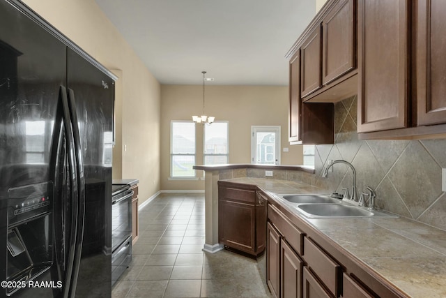 kitchen featuring hanging light fixtures, black appliances, sink, light tile patterned floors, and decorative backsplash