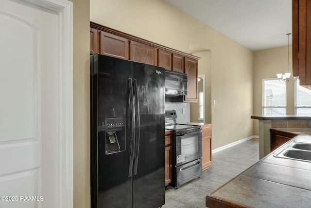 kitchen with black appliances, sink, light tile patterned floors, a chandelier, and pendant lighting