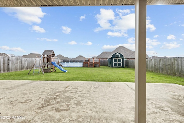 view of jungle gym with a storage unit, a patio, a pool, and a lawn