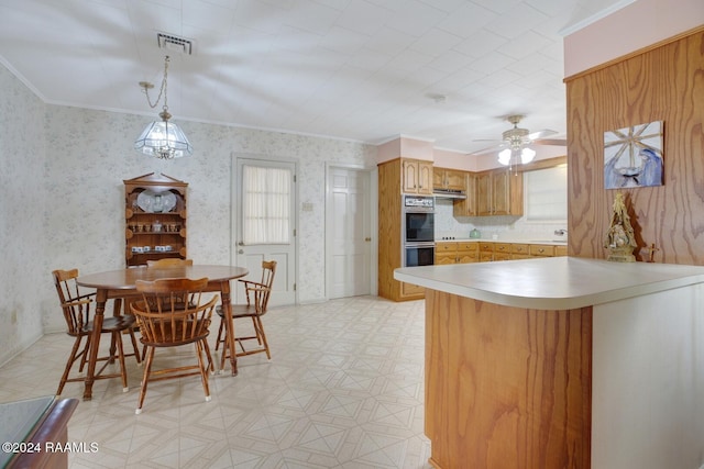 kitchen featuring double oven, kitchen peninsula, ornamental molding, decorative light fixtures, and ceiling fan