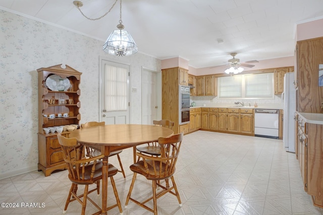 dining space featuring ornamental molding, sink, and ceiling fan with notable chandelier