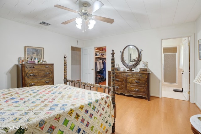 bedroom featuring a closet, ceiling fan, light hardwood / wood-style flooring, and a walk in closet