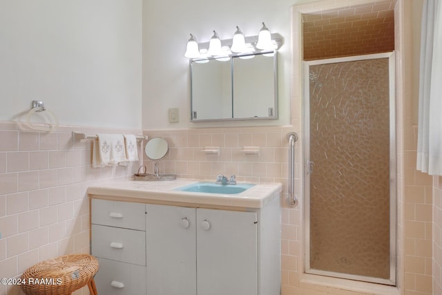 bathroom featuring vanity, an enclosed shower, and tile walls