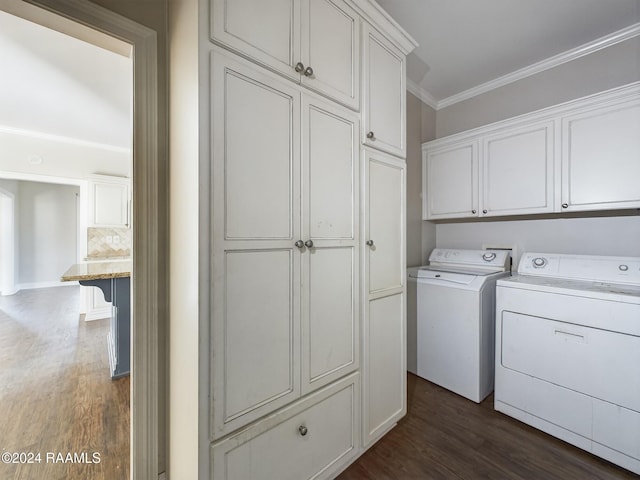 washroom featuring cabinets, crown molding, washing machine and dryer, and dark wood-type flooring