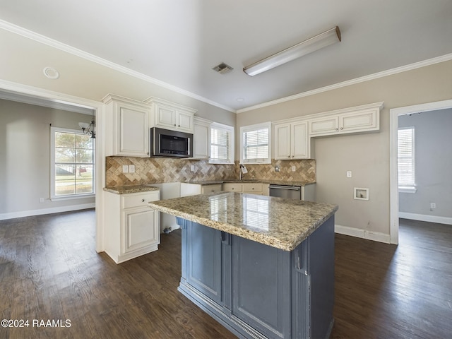 kitchen featuring white cabinets, stainless steel appliances, light stone counters, and tasteful backsplash