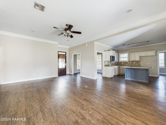 unfurnished living room with ceiling fan, dark hardwood / wood-style flooring, and ornamental molding