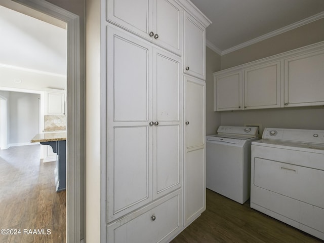 laundry room with dark hardwood / wood-style flooring, cabinets, ornamental molding, and washing machine and dryer