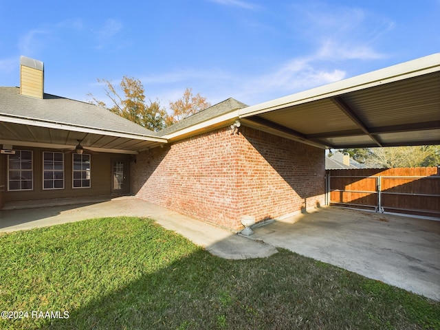 view of side of home featuring a yard and ceiling fan