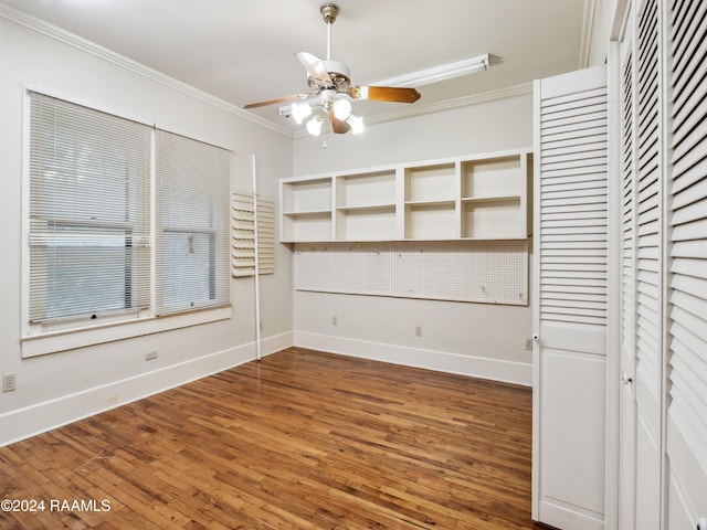 unfurnished dining area featuring dark hardwood / wood-style flooring, ceiling fan, and crown molding