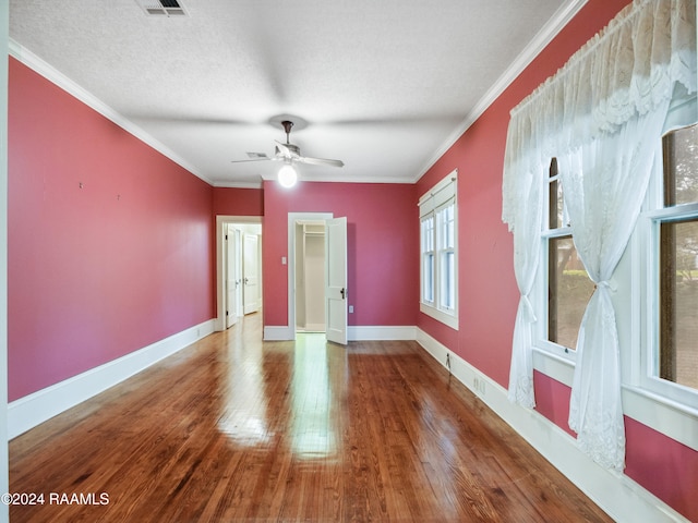 unfurnished room with ceiling fan, wood-type flooring, a textured ceiling, and ornamental molding