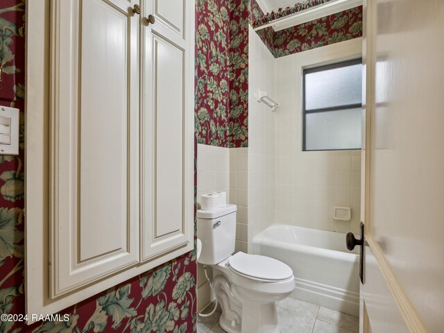 243 W Grolee St, Opelousas, LA 70570 - bathroom with wallpapered walls, toilet, tile patterned flooring, bathing tub / shower combination, and wainscoting