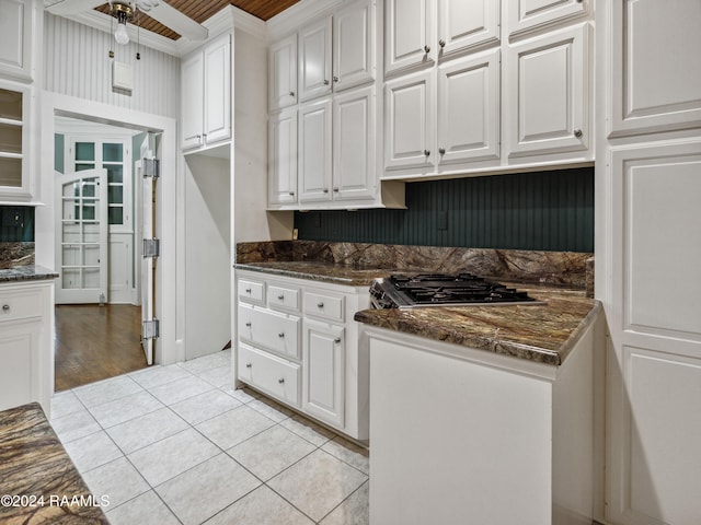 kitchen featuring light hardwood / wood-style flooring, dark stone counters, ornamental molding, and white cabinets