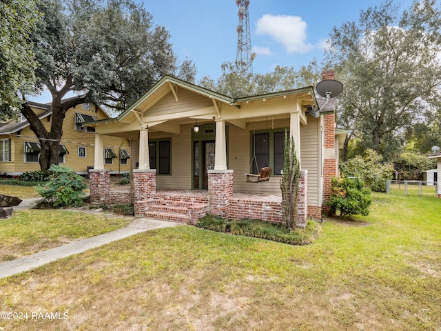 view of front of home featuring covered porch and a front lawn