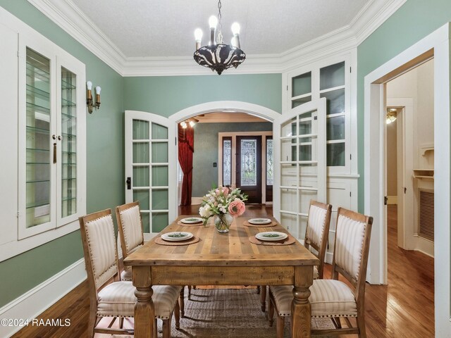 243 W Grolee St, Opelousas, LA 70570 - dining room with a chandelier, arched walkways, ornamental molding, wood finished floors, and french doors