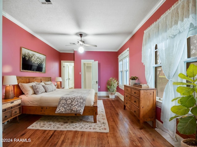 bedroom with dark hardwood / wood-style flooring, ornamental molding, a textured ceiling, and ceiling fan