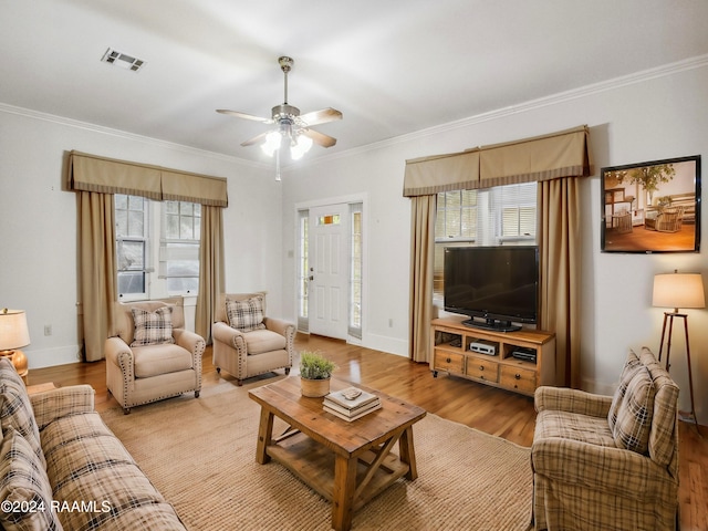 living room featuring ornamental molding, light hardwood / wood-style floors, and plenty of natural light