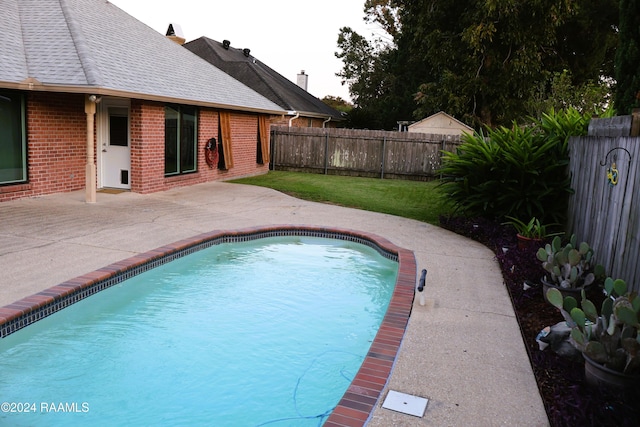 view of pool with a yard and a patio