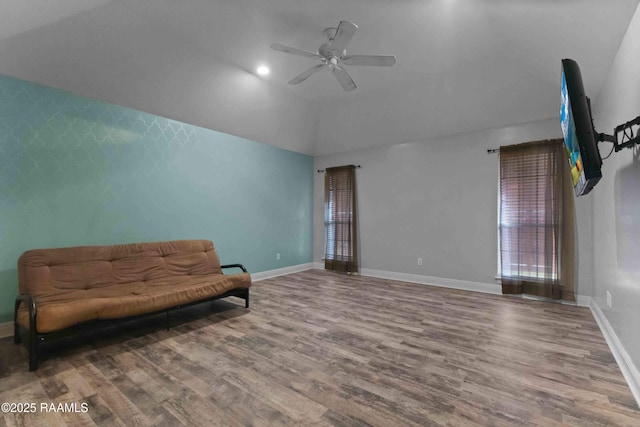 living area with wood-type flooring, lofted ceiling, and ceiling fan