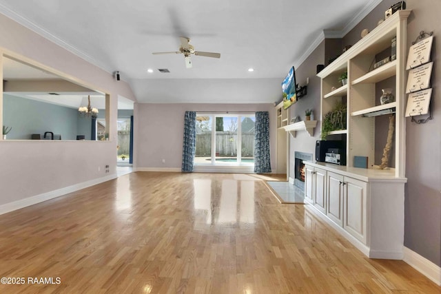 unfurnished living room featuring ceiling fan with notable chandelier, lofted ceiling, ornamental molding, and light hardwood / wood-style floors