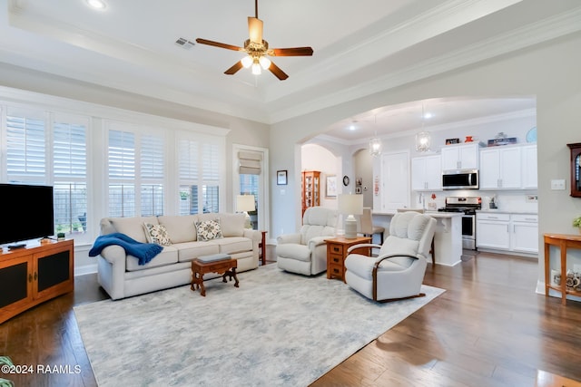 living room featuring crown molding, ceiling fan, wood-type flooring, and a raised ceiling